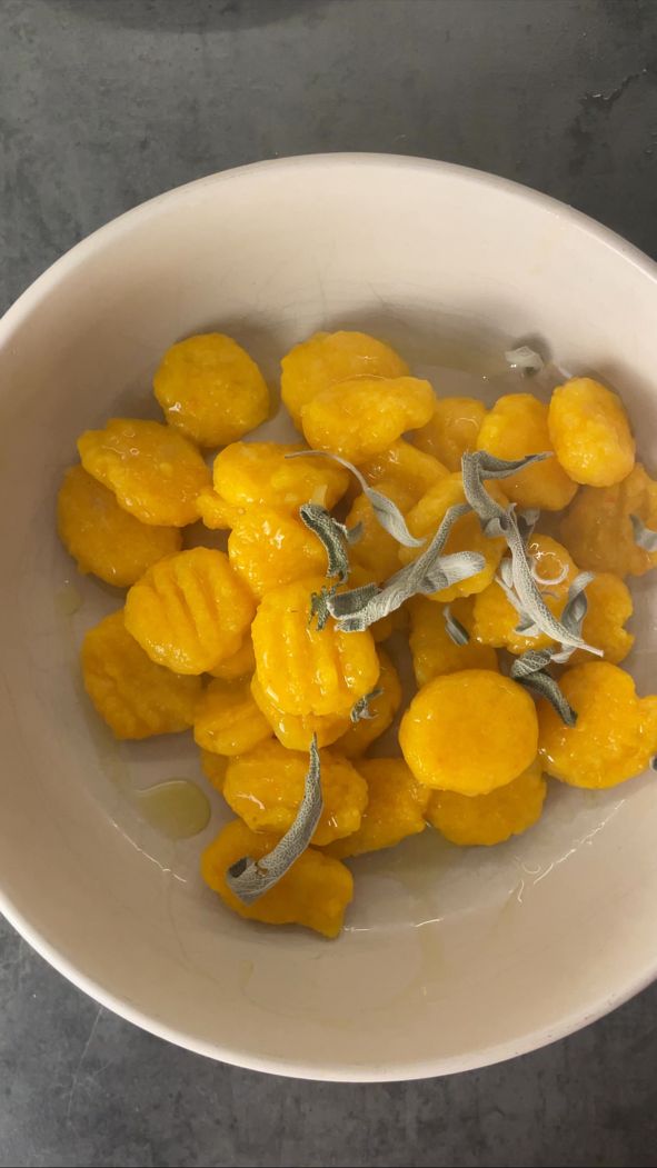 Gekochte Kürbis-Gnocchi mit Salbei und Olivenöl in einer weißen Schale