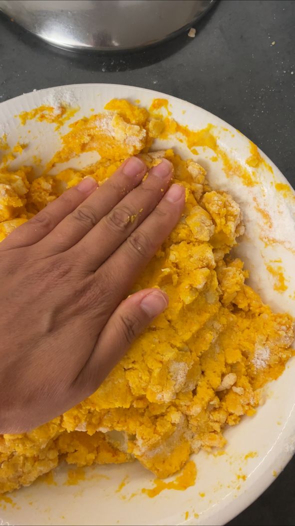 Glutenfreier Kürbis-Gnocchi-Teig wird mit der Hand kurz zusammengedrückt