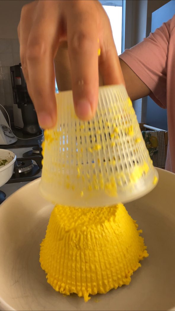 Veganer Ricotta wird aus dem Körbchen auf einen Teller gestürzt